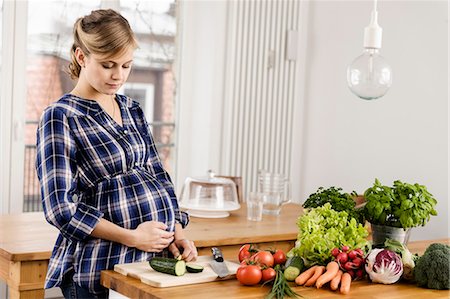 Pregnant woman chopping vegetables Foto de stock - Sin royalties Premium, Código: 649-06000452