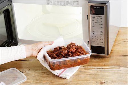 Woman heating leftovers in microwave Stock Photo - Premium Royalty-Free, Code: 649-06000564