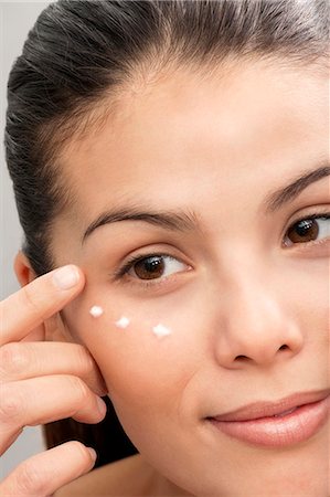 simsearch:649-06305302,k - Woman applying moisturizer to face Foto de stock - Sin royalties Premium, Código: 649-06000654