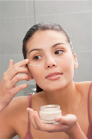 Woman applying moisturizer to face Foto de stock - Royalty Free Premium, Número: 649-06000653