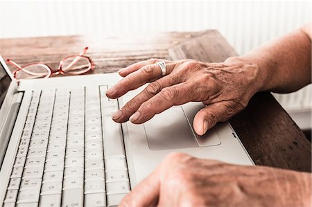 Fermer vers le haut des anciens mans mains sur ordinateur portable Photographie de stock - Premium Libres de Droits, Code: 649-06000708