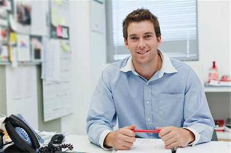 smiling businessman in office - Smiling businessman sitting at desk Stock Photo - Premium Royalty-Free, Code: 649-06000826