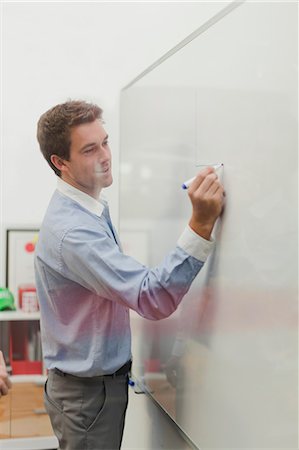 Businessman writing on whiteboard Stock Photo - Premium Royalty-Free, Code: 649-06000834