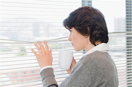 Businesswoman peering out office window Stock Photo - Premium Royalty-Free, Code: 649-06000917