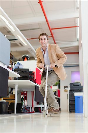 enjoying with scooter - Businessman riding scooter in office Stock Photo - Premium Royalty-Free, Code: 649-06000927