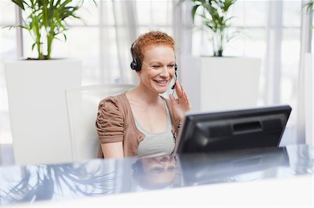 fone de ouvido - Receptionist wearing headset at desk Foto de stock - Royalty Free Premium, Número: 649-06000937