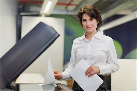 Businesswoman making copies in office Foto de stock - Sin royalties Premium, Código: 649-06000950