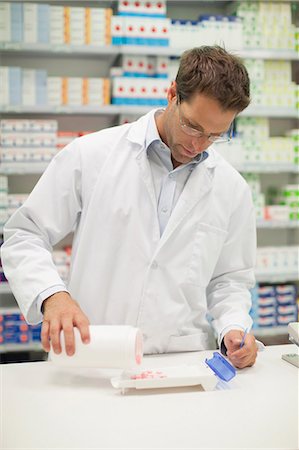 simsearch:649-06001030,k - Pharmacist counting pills at counter Foto de stock - Sin royalties Premium, Código: 649-06001036