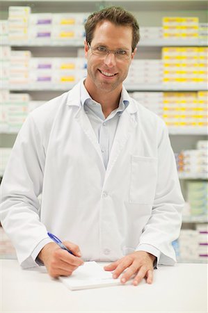 prescription - Pharmacist making notes at counter Stock Photo - Premium Royalty-Free, Code: 649-06001033