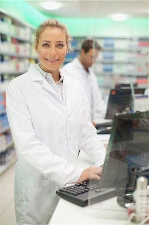 Pharmacist using computer at counter Stock Photo - Premium Royalty-Free, Code: 649-06001042