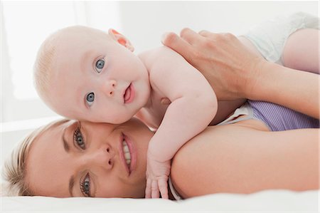 diapering mother to baby - Hugging bébé sur le lit de la mère Photographie de stock - Premium Libres de Droits, Code: 649-06001119