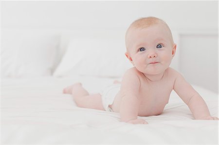 simsearch:6110-06702760,k - Smiling baby laying on bed Fotografie stock - Premium Royalty-Free, Codice: 649-06001129