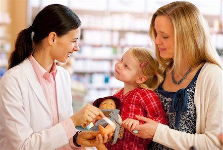 Pharmacist putting bandage on doll Foto de stock - Sin royalties Premium, Código: 649-06001307