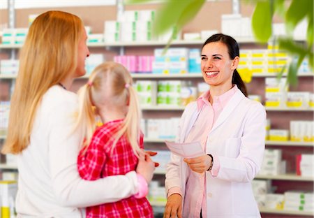 Pharmacist giving prescription to mother Stock Photo - Premium Royalty-Free, Code: 649-06001308