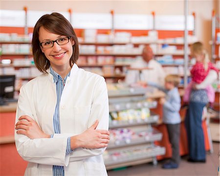 person at pharmacy - Smiling pharmacist standing in store Stock Photo - Premium Royalty-Free, Code: 649-06001312