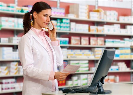 Pharmacist talking on phone at counter Stock Photo - Premium Royalty-Free, Code: 649-06001334