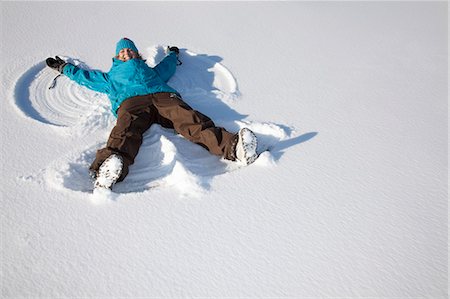 female mischievous grin - Woman making snow angel on field Stock Photo - Premium Royalty-Free, Code: 649-06001352