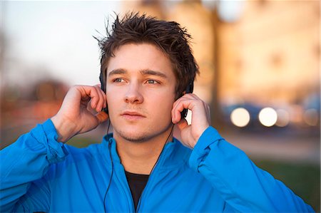 Man listening to headphones outdoors Foto de stock - Sin royalties Premium, Código: 649-06001382