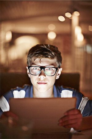 eyeglasses teenager boy - Man illuminated by tablet computer Stock Photo - Premium Royalty-Free, Code: 649-06001684