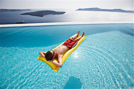 Teenage boy relaxing on raft in pool Foto de stock - Sin royalties Premium, Código: 649-06001699