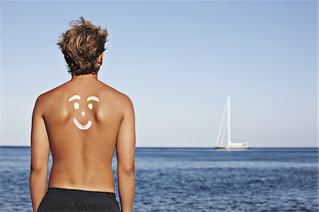 santorini island greece and people - Boy with drawing in sunscreen on back Stock Photo - Premium Royalty-Free, Code: 649-06001703