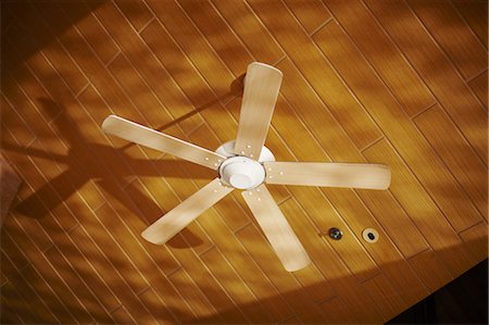 Wooden ceiling fan casting shadows Stock Photo - Premium Royalty-Free, Code: 649-06001716