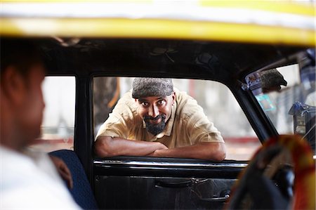 driver passenger - Smiling man leaning in taxi cab window Stock Photo - Premium Royalty-Free, Code: 649-06001738