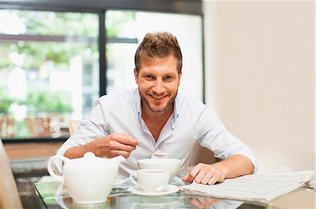 eating - Smiling man eating breakfast at table Foto de stock - Sin royalties Premium, Código: 649-06040103