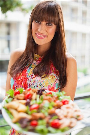 serving food - Woman offering plate of salad outdoors Stock Photo - Premium Royalty-Free, Code: 649-06040136