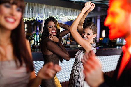 Smiling friends dancing in bar Stock Photo - Premium Royalty-Free, Code: 649-06040176