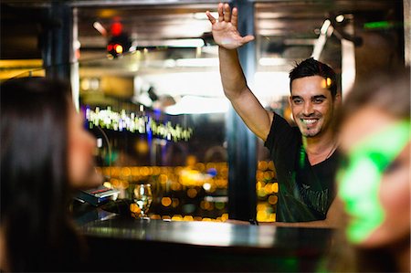 people nightlife clubs - Bartender waving to customers in bar Stock Photo - Premium Royalty-Free, Code: 649-06040195