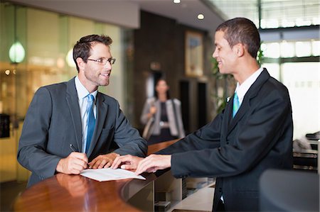 standing desk - Businessman checking into hotel Stock Photo - Premium Royalty-Free, Code: 649-06040226