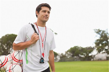 single blank bag - Coach carrying soccer balls on pitch Stock Photo - Premium Royalty-Free, Code: 649-06040285