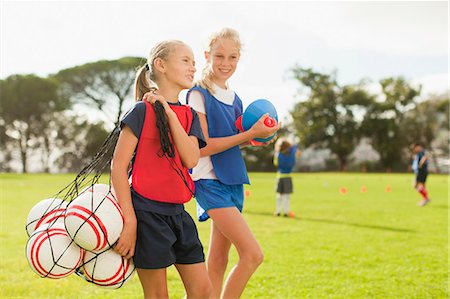 football uniforms for kids - Girl carrying soccer balls on pitch Stock Photo - Premium Royalty-Free, Code: 649-06040280