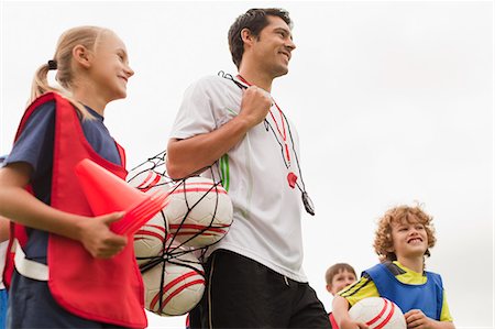 Coach carrying soccer balls on pitch Foto de stock - Sin royalties Premium, Código: 649-06040282