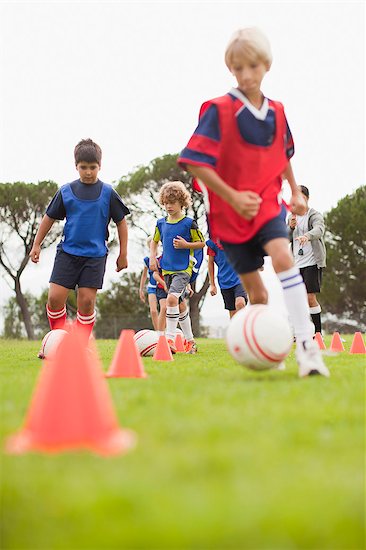 Childrens soccer team training on pitch Stock Photo - Premium Royalty-Free, Image code: 649-06040292