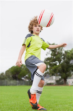 soccer goals - Boy playing with soccer ball in field Stock Photo - Premium Royalty-Free, Code: 649-06040328