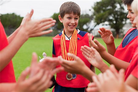 futbolista (hombre y mujer) - Children cheering teammate with trophy Foto de stock - Sin royalties Premium, Código: 649-06040323