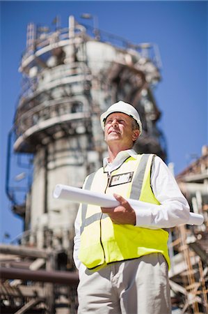 Worker with blueprints at oil refinery Stock Photo - Premium Royalty-Free, Code: 649-06040366