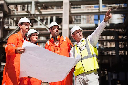 Workers with blueprints at oil refinery Foto de stock - Royalty Free Premium, Número: 649-06040362