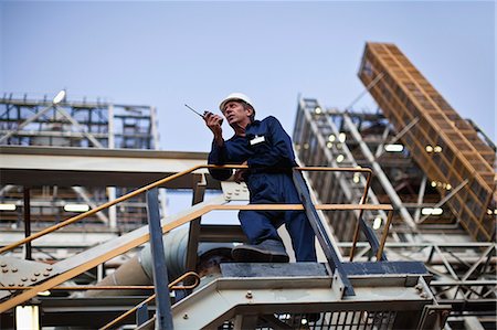 Worker using walkie talkie on site Foto de stock - Sin royalties Premium, Código: 649-06040437