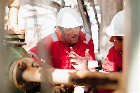 refinería - Workers examining equipment on site Foto de stock - Sin royalties Premium, Código: 649-06040467
