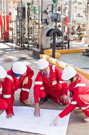 Workers with blueprints at oil refinery Stock Photo - Premium Royalty-Free, Code: 649-06040475