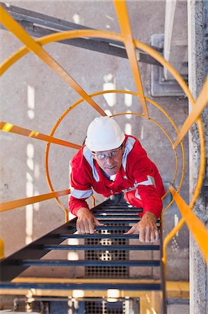 Worker climbing ladder at oil refinery Foto de stock - Sin royalties Premium, Código: 649-06040482