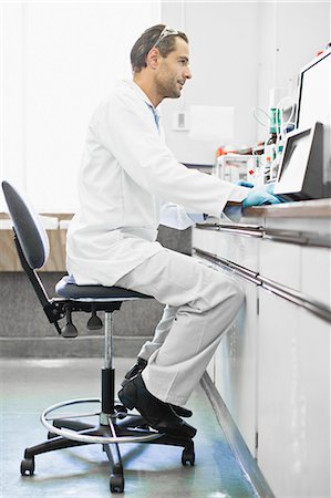 side view of someone sitting in chair - Scientist using computer in lab Stock Photo - Premium Royalty-Free, Code: 649-06040517