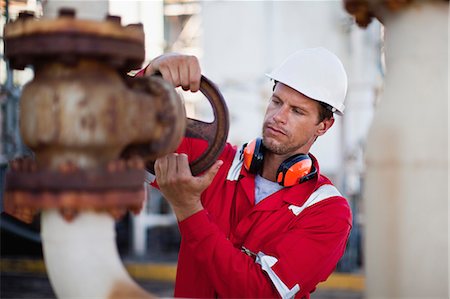 Worker adjusting gauge at chemical plant Stock Photo - Premium Royalty-Free, Code: 649-06040548