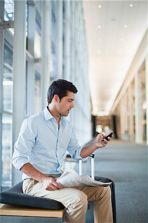 suitcase travelling - Businessman using cell phone in lobby Stock Photo - Premium Royalty-Free, Code: 649-06040646