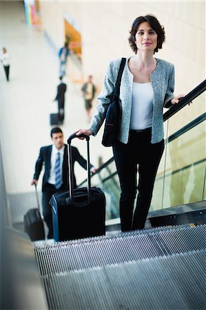 south africa and black and business - Businesswoman riding escalator Stock Photo - Premium Royalty-Free, Code: 649-06040643