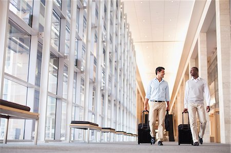 pictures of two people talking at the airport - Businessmen rolling luggage in hallway Stock Photo - Premium Royalty-Free, Code: 649-06040650