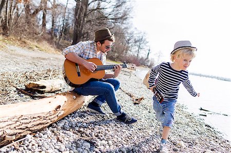 pebble - Father and son with guitars by creek Stock Photo - Premium Royalty-Free, Code: 649-06040819